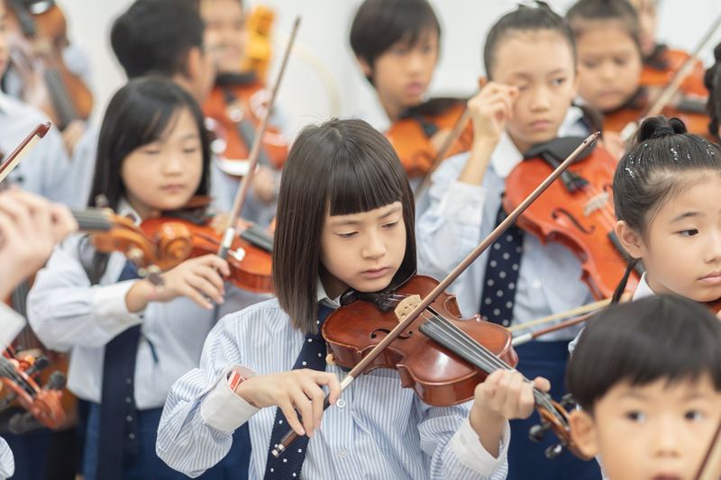A young violinist playing with the school ensemble